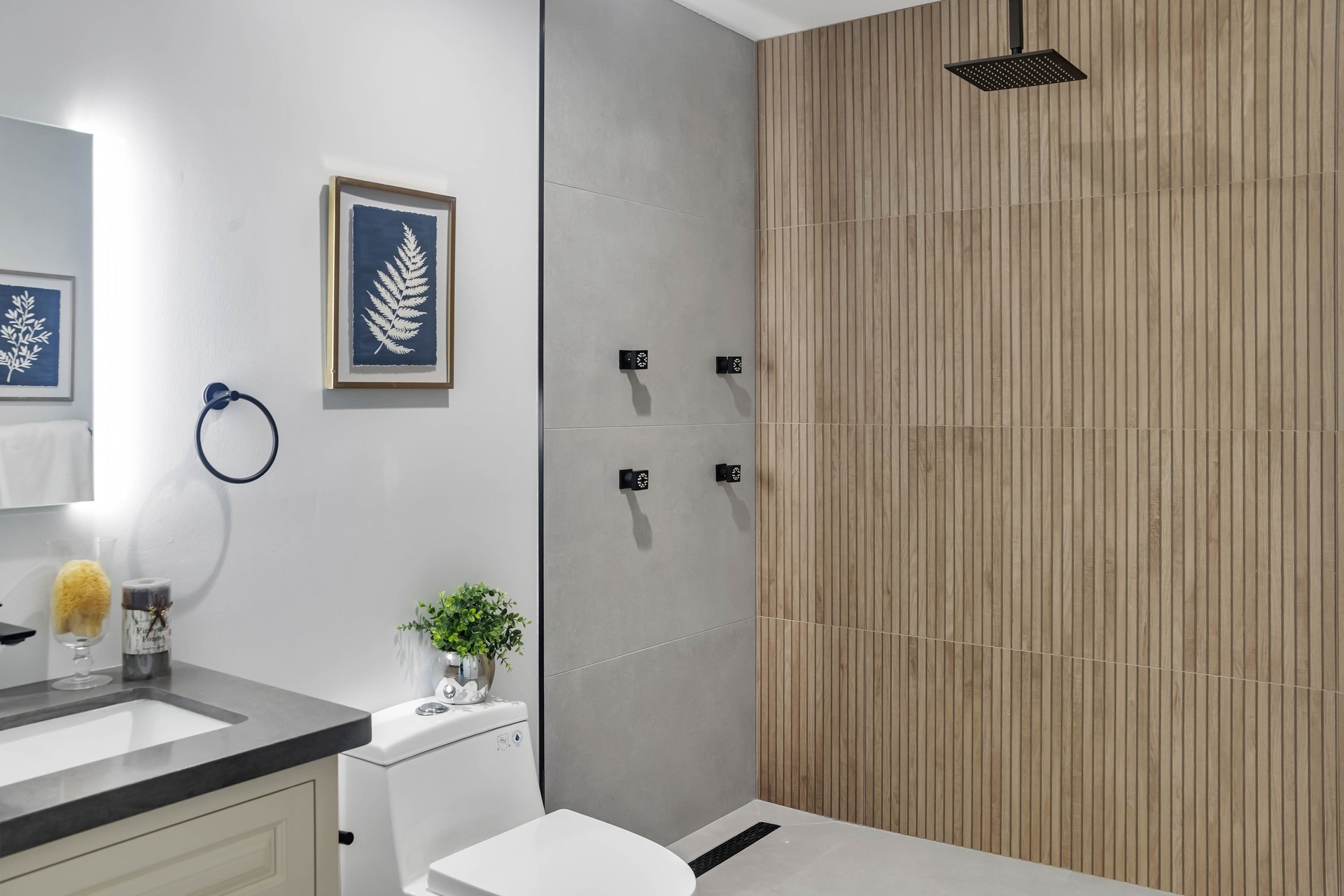 Bathroom with a wood-look slat tile shower wall, rain showerhead and black fixtures