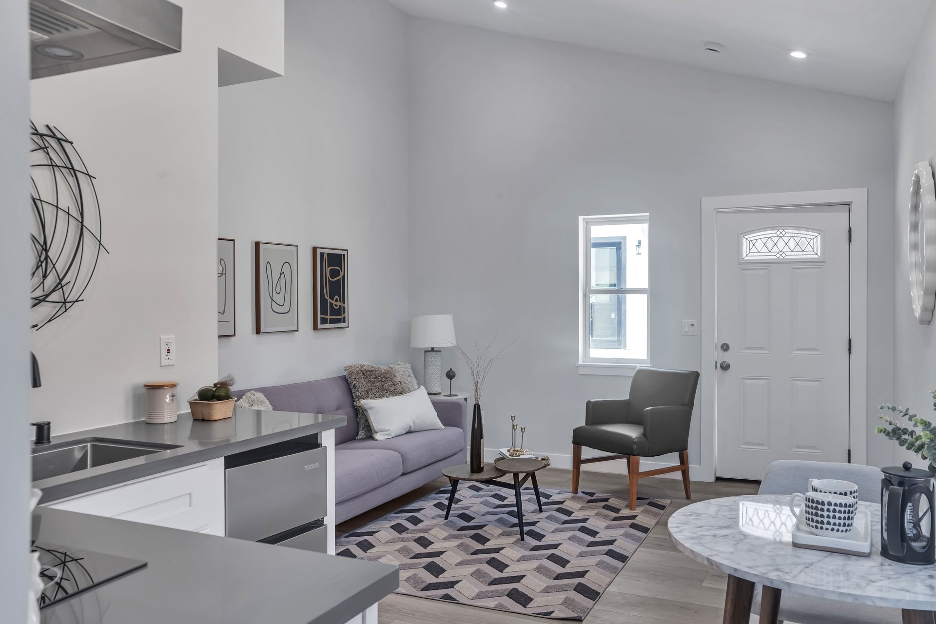 Small living area with an entry door, kitchenette counter and round dining table